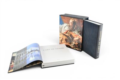 un livre ouvert posé sur une table blanche à côté d'un livre