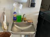 un évier dans un coin de la cuisine, avec une poubelle