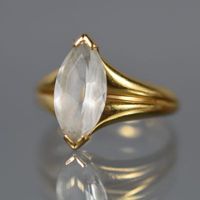 un gros plan d'une bague en or sertie d'un quartz transparent