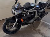une moto noire garée dans un garage, à côté d'une porte de garage