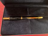 a pen in a black case on a red surface