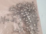 a bag of screws on a table with a plastic bag
