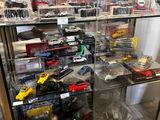 many toy cars on display in a glass case