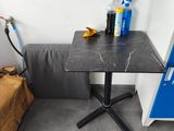 une petite table sur laquelle se trouve une bouteille de produit nettoyant, dans un coin de la pièce