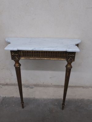 a marble top table with a gold frame on it