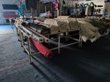 many rolls of fabric on a conveyor belt in a factory