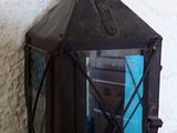 une lanterne noire contenant un verre bleu