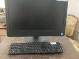 une image représentant un ordinateur de bureau posé sur un bureau en bois