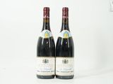deux bouteilles de vin posées l'une à côté de l'autre sur une surface blanche