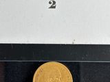 a close up of a gold coin on display in a glass case