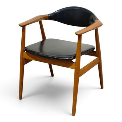 a wooden chair with black leather seat on a white background