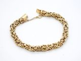 un bracelet à chaîne en or avec un fermoir sur fond blanc