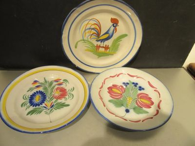 trois assiettes ornées de motifs colorés, posées sur un comptoir