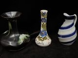 three vases that are sitting on a black surface
