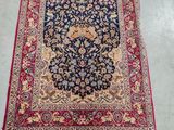 a blue rug with a red border and a floral design on it