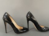 black high heeled pumps on a grey surface
