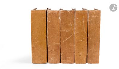 several brown books stacked on top of each other on a white surface