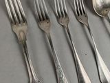 a lot of silver spoons and forks on the table