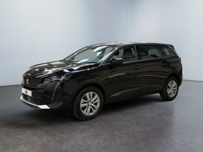a black car is parked in a room with a white wall