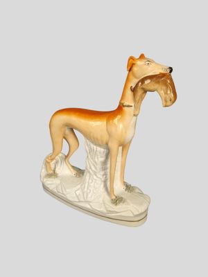 figurine of a dog with a collar on a white base