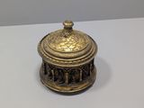 an antique brass box with a lid on a white surface