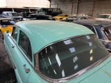 many old cars parked in a garage next to each other