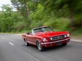 a red car driving down the road with trees in the background