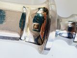 a close up of a silver object on a white surface