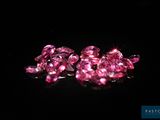 a bunch of pink diamonds sitting on top of a black surface