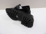 black leather shoes with rubber soles on a white surface