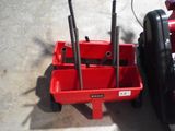 a small red cart with tools in it next to a bike