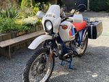 une moto garée sur le gravier près d'un banc