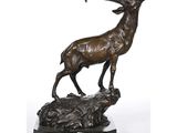 an image of a bronze statue of a stag on a rock