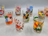 plusieurs verres ornés de personnages de dessins animés, posés sur une table