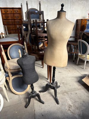 un mannequin assis sur une table à côté d'une chaise dans une pièce