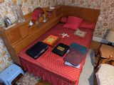 un petit lit dans un coin d'une pièce au sol en parquet