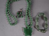 necklace, bracelet, and ring made of jade beads on a white surface