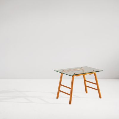 une petite table en verre avec des pieds en bois et un plateau en verre