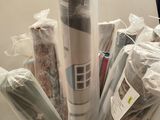 many rolls of fabric in a cardboard box on the floor