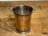 a silver cup sitting on a wooden table
