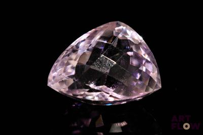 une image représentant un diamant rose posé sur une surface noire