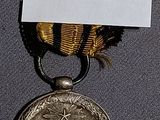 une médaille d'or entourée d'un ruban noir et jaune