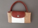 un sac à main marron et blanc accroché au mur