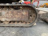 a close up of a tractor track with a machine in the background
