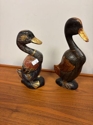 two ducks that are sitting on a wooden table