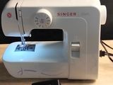 a sewing machine sitting on a table with a phone