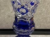 une image représentant un vase en verre bleu posé sur une table