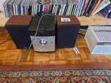 two speakers sitting on a wooden table in front of a bookshelf