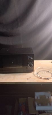 un téléviseur posé sur une table en bois, avec une télécommande dessus