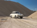 a white car that is driving down a dirt road